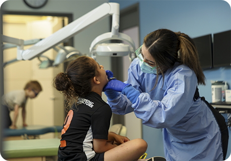 Dentist showing a tablet to a young boy in the dental chair